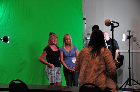 film crew filming two people in front of a green screen