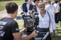 camera operator films an actor using a camera on a film production set