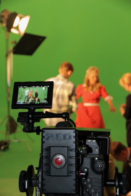 camera and monitor in front of green screen and talent