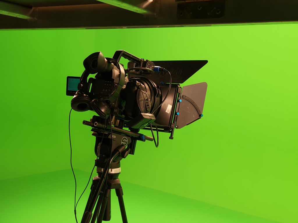 broadcast camera in studio in front of green screen